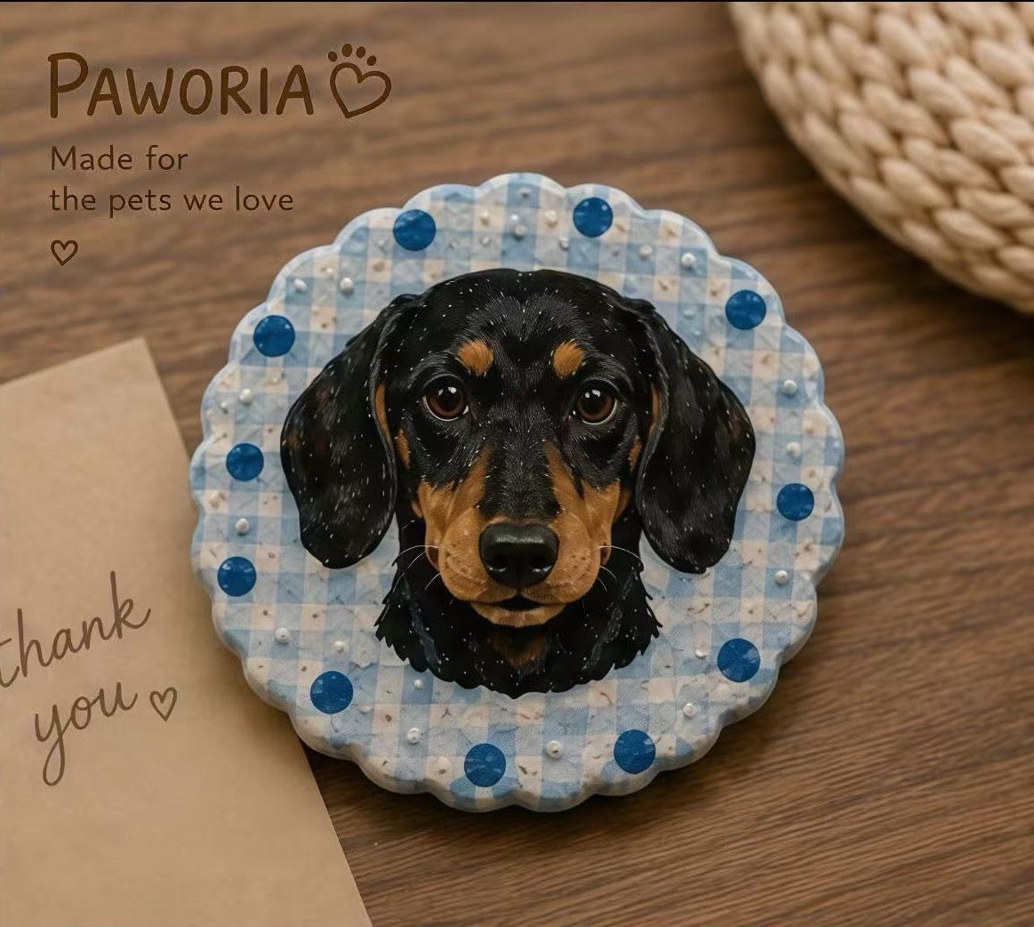 Round pet clay sculpture of a black and tan dachshund with blue dotted border