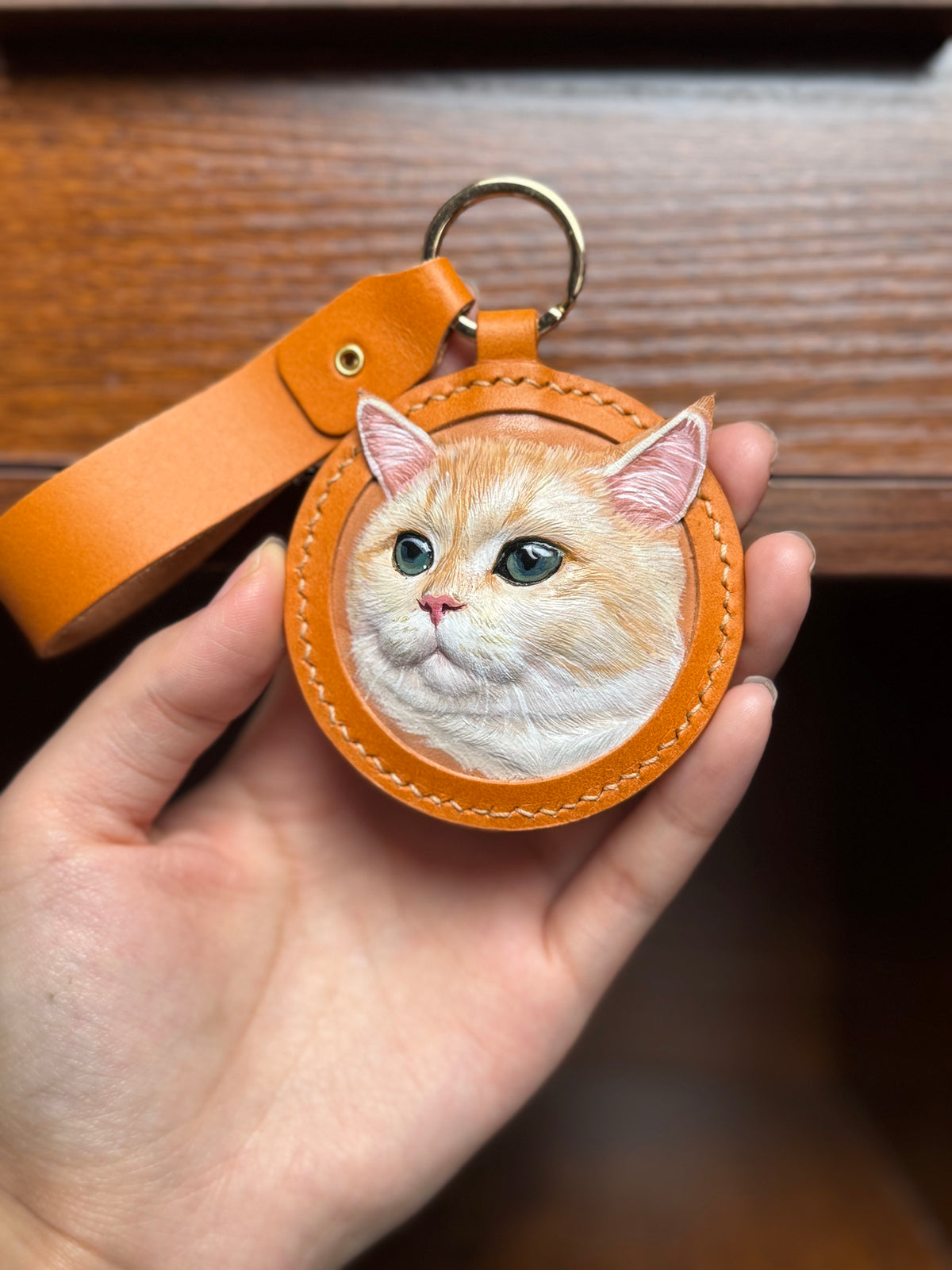 Cat face key ring ornament in orange stitched leather with gold ring and strap