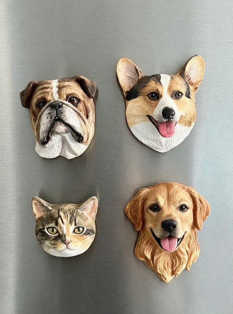 3D pet fridge magnets on a board—four dog and cat face heads in a grid.