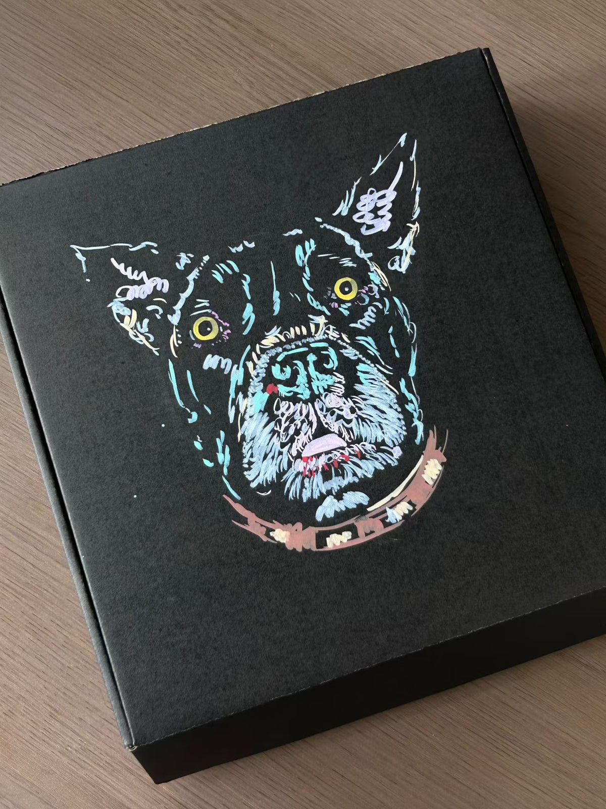 Scratchboard pet portrait on black board with colorful dog face artwork